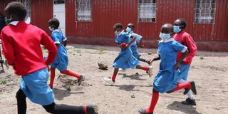 Learners run to class after break time at Star of Hope Primary in Industrial Area