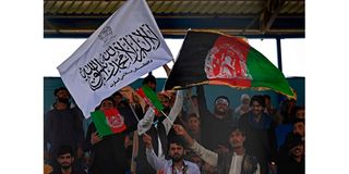 Spectators wave Afghanistan's and Taliban flags as they watch the Twenty20 cricket trial match