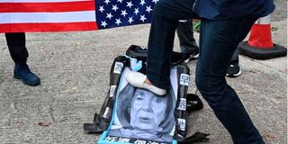 A pro-Beijing protester stamps on an image depicting the US House Speaker Nancy Pelosi