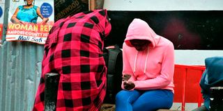 Residents sit at a corner all covered up to keep warm