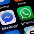 The logos of the Telegram, Facebook messenger and the WhatsApp applications are displayed on the screen of an Apple iPhone