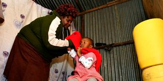 Bridgette Ndanu prepares her granddaughter Ruth Nyawira to go to school