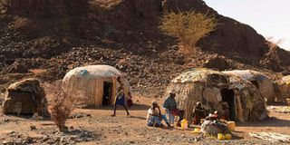 El Molo family sits outside their new makeshift house