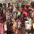 Members of the public wait for their rations of relief food
