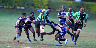Kabras Sugar RFC forward Eugene Sifuna (centre) charges past Mean Machine's defenders