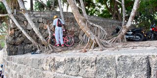 A man parks his bicycle near the shore of the Indian Ocean along Bamburi Beach