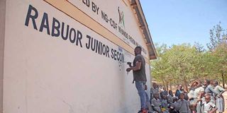 A worker puts the final touches on a classroom at Rabuor Junior Secondary School