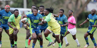 Darwin Mukidza (centre) of KCB charges past Kabras Sugar defenders