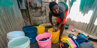 Maxmilla Lihavi, 30 years and a single mother of four children washes clothes for one of her clients
