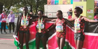 Team Kenya celebrate with the flag after women's half marathon race