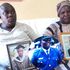 Devastated Dickson Litali and his wife Everline Litali hold portraits of their son Captain Hillary Litali