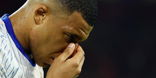 Kylian Mbappe holds his face