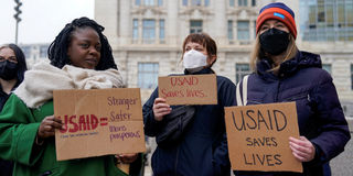 People hold placards outside the USAID building