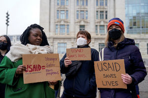 People hold placards outside the USAID building